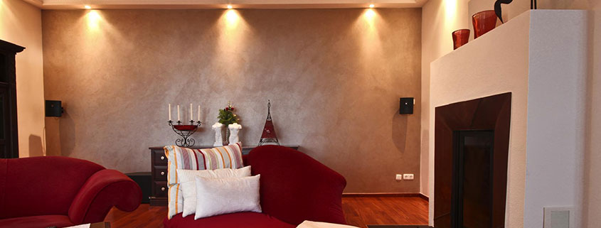 Ein Wohnzimmer mit Deckenlichtern und einem rustikalen Flair