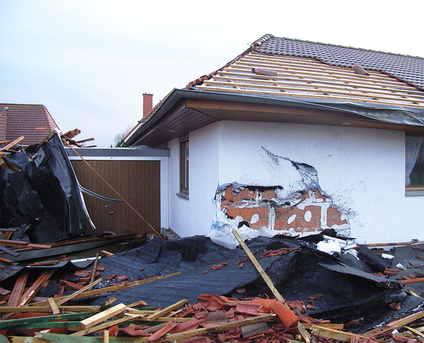 Haus durch Sturm beschädigt. Abgerissenes Dach und kaputte Fassade.
