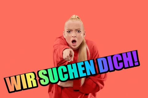 Eine blonde Frau mit rotem Pullover steht in der Uncle-Sam-Pose da und zeigt mit dem Zeigefinger in die Kamera. Der Gesichtsausdruck ist überrascht oder erwischend. Über dem Bild ist ein Schriftzug in blinkenden Regenbogenfarben "Wir suchen dich". Der Hintergrund ist rot.
